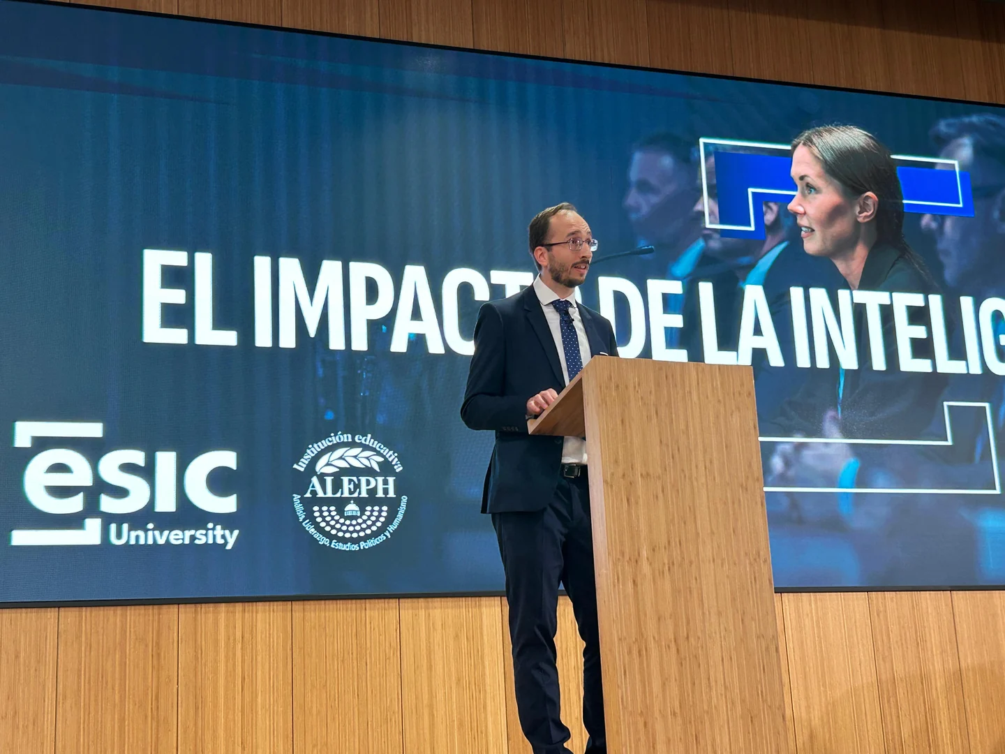 Pablo Martín speaking at the lectern in front of the event title and ESIC and ALEPH logos.
