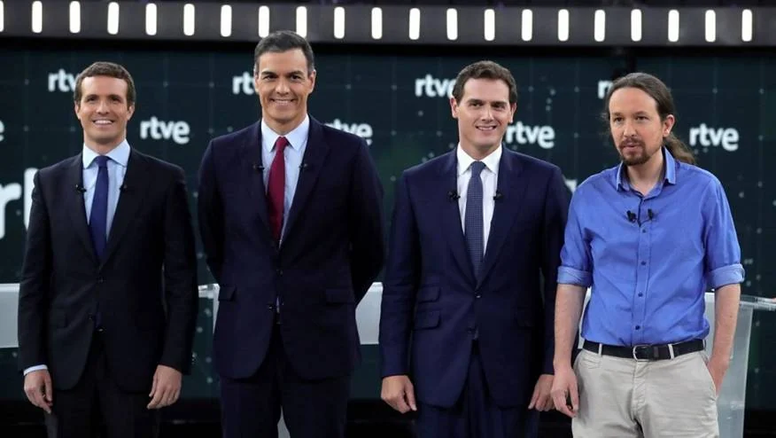 Original photograph of four debate participants standing in front of a Televisión Española backdrop.