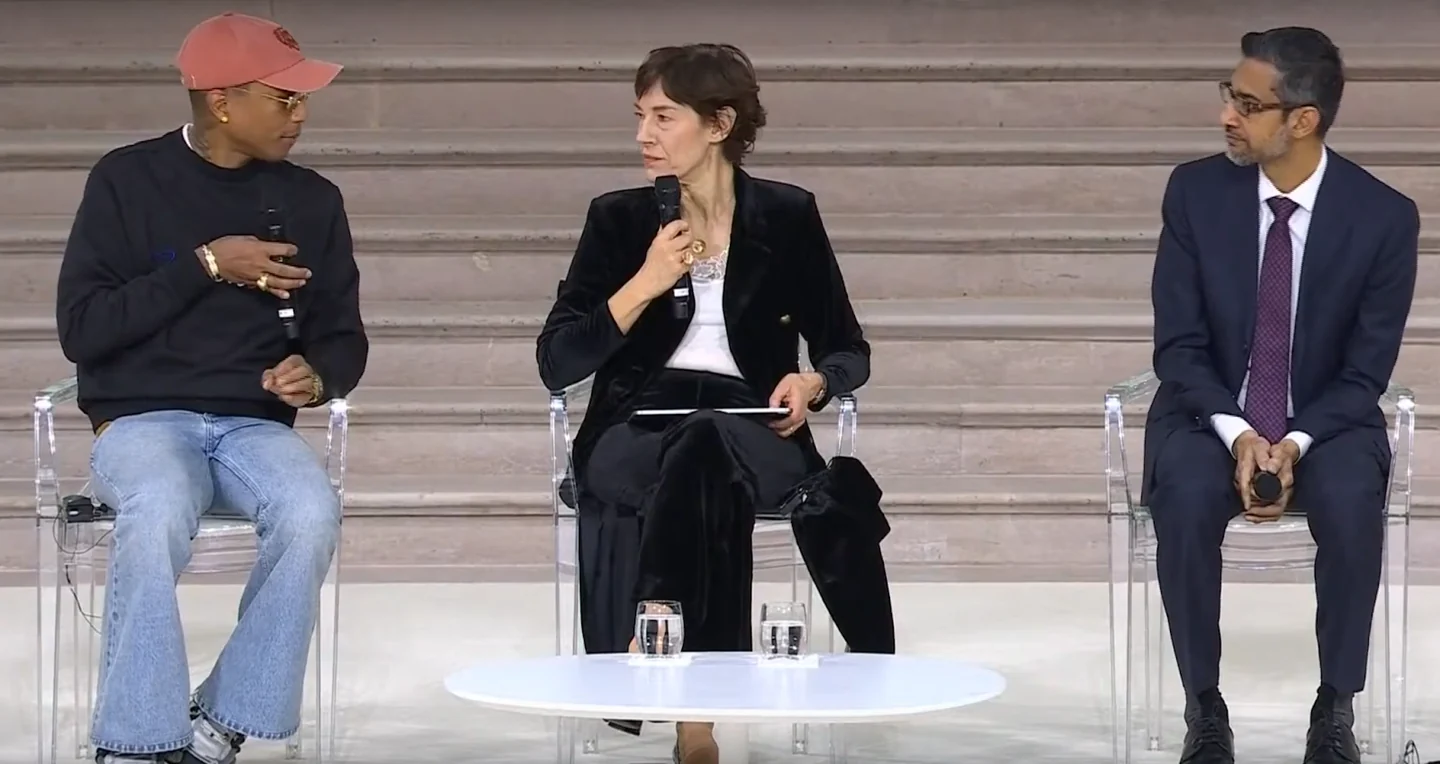 Three participants seated with microphones during the summit conversation discussed in the article.