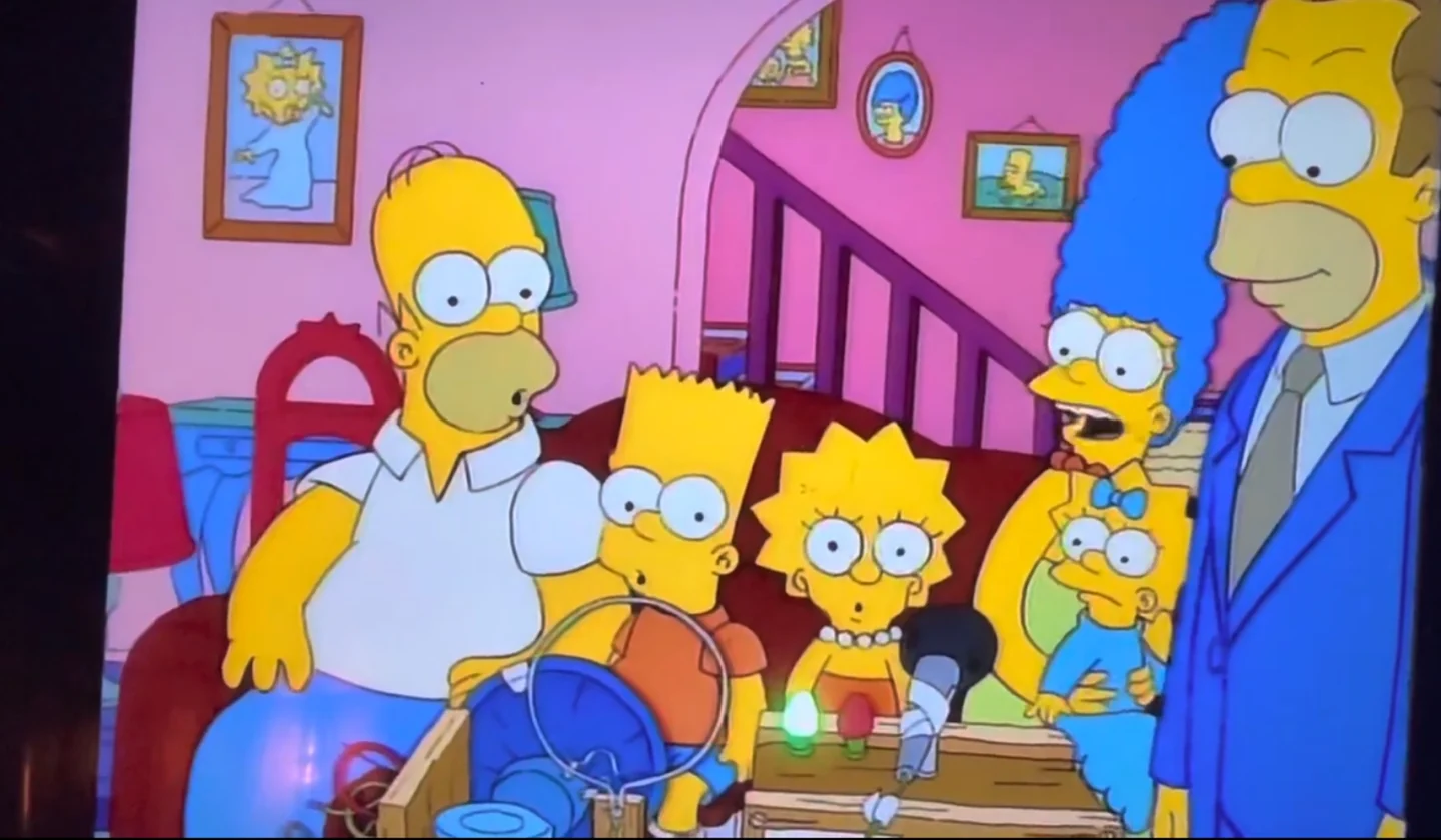 Herb demonstrates his baby translator to the Simpson family.